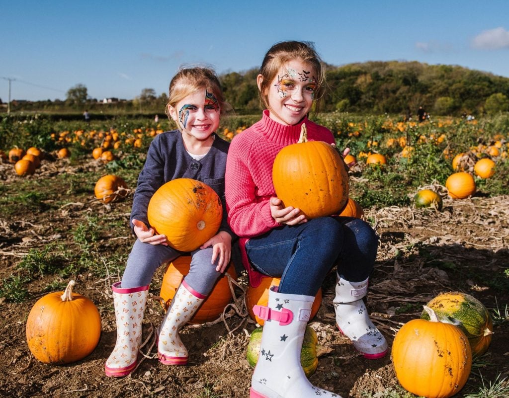 girl with pumpkin at over farm