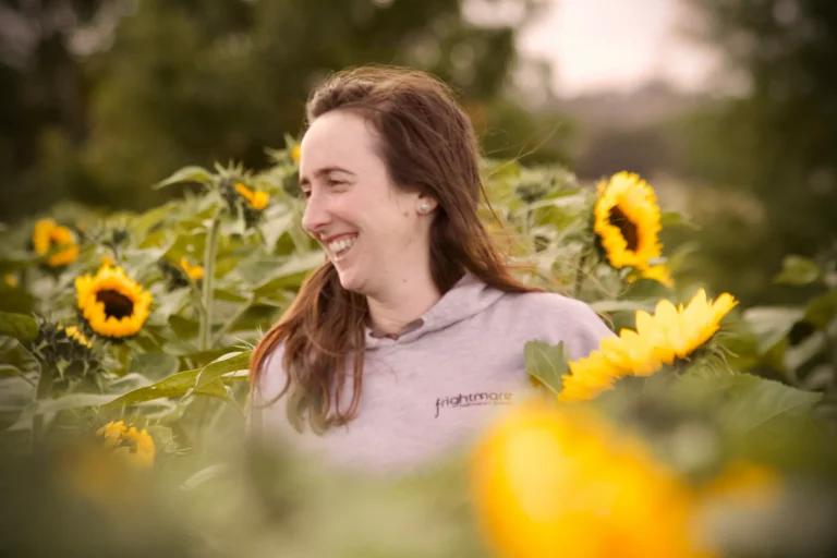 Lady in sunflower field smiling
