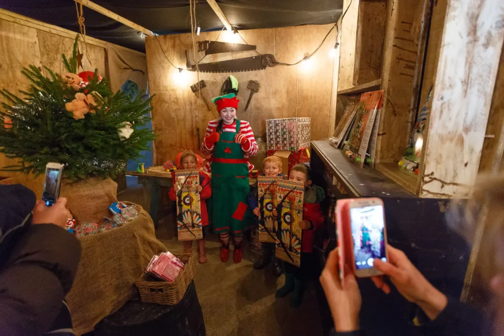 Elf with children and presents in elf workshop
