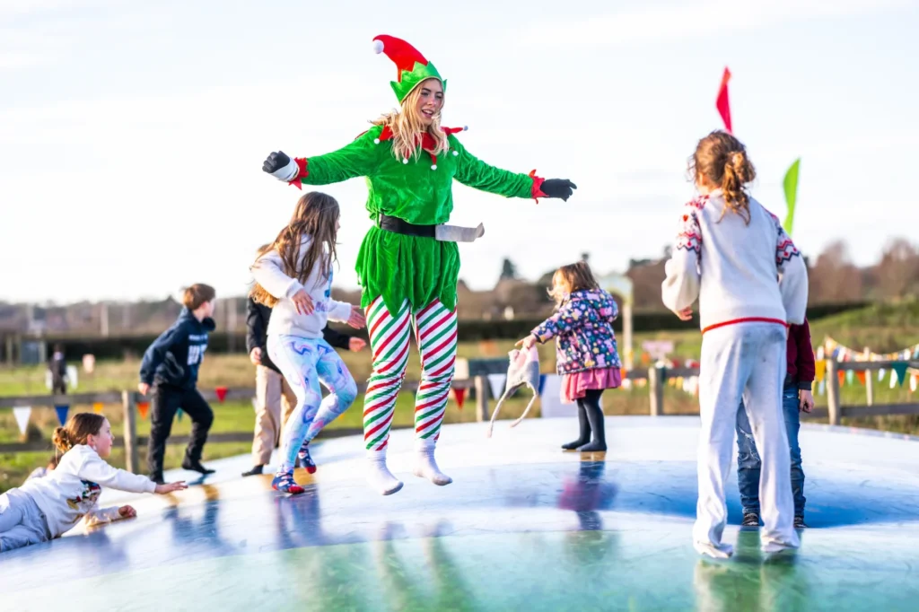 Kids and Elf on pillows in farm park at Christmas